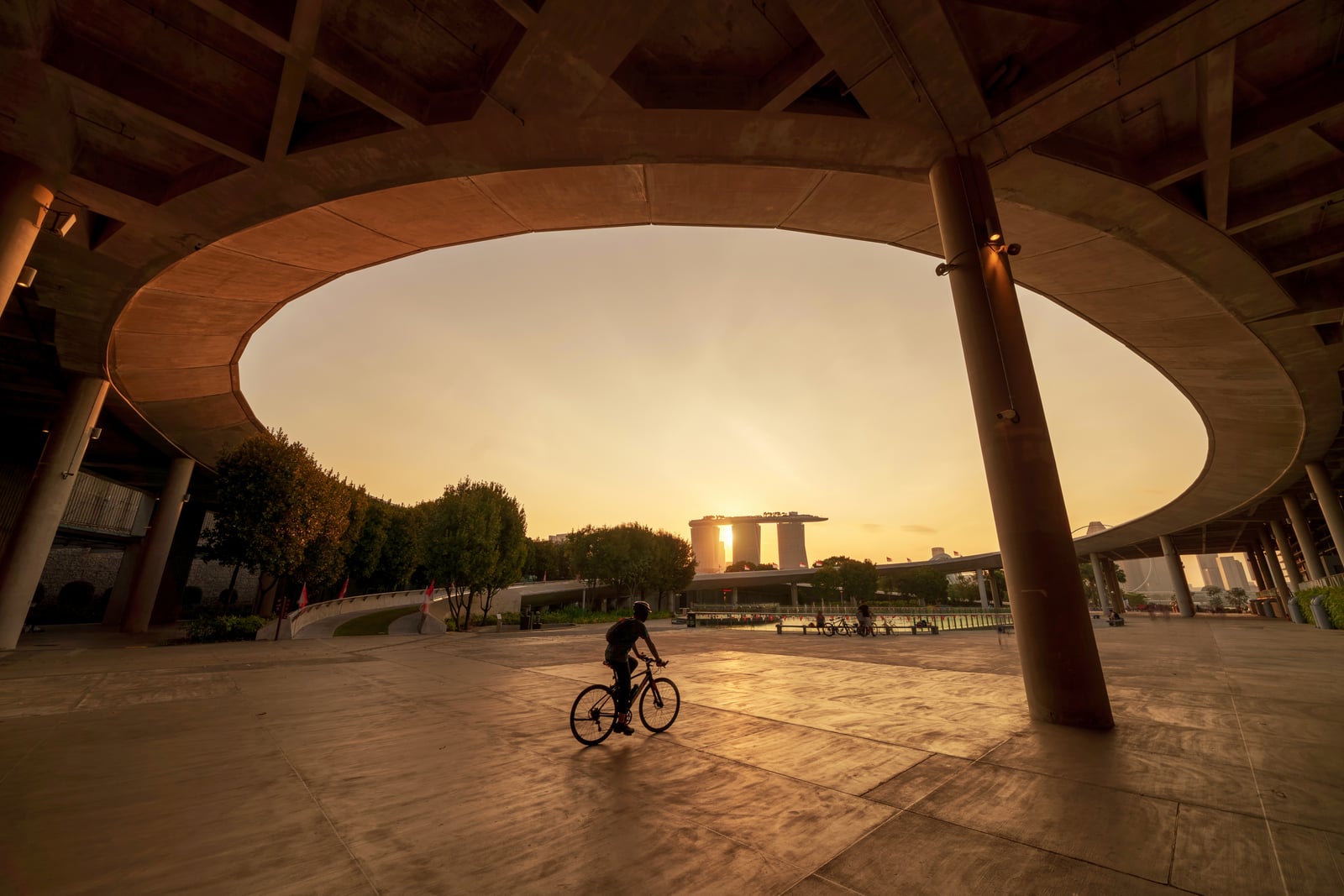 Cyclist riding past Marina Bay Sands in Singapore at sunset